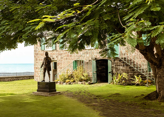 a statue of a man in a uniform in front of a stone building