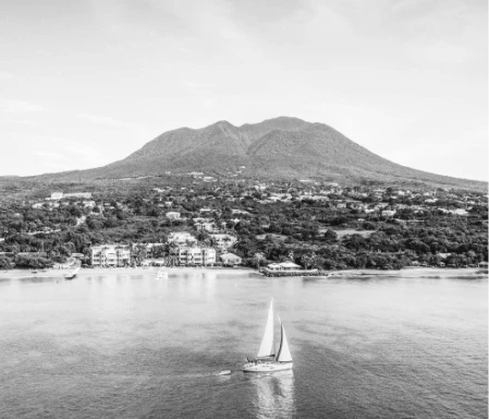 a sailboat in the water with a mountain in the background