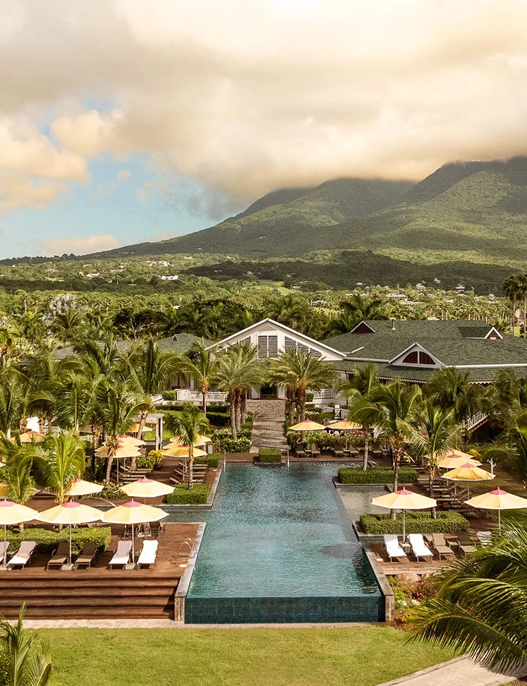 a pool with umbrellas and chairs in front of a resort