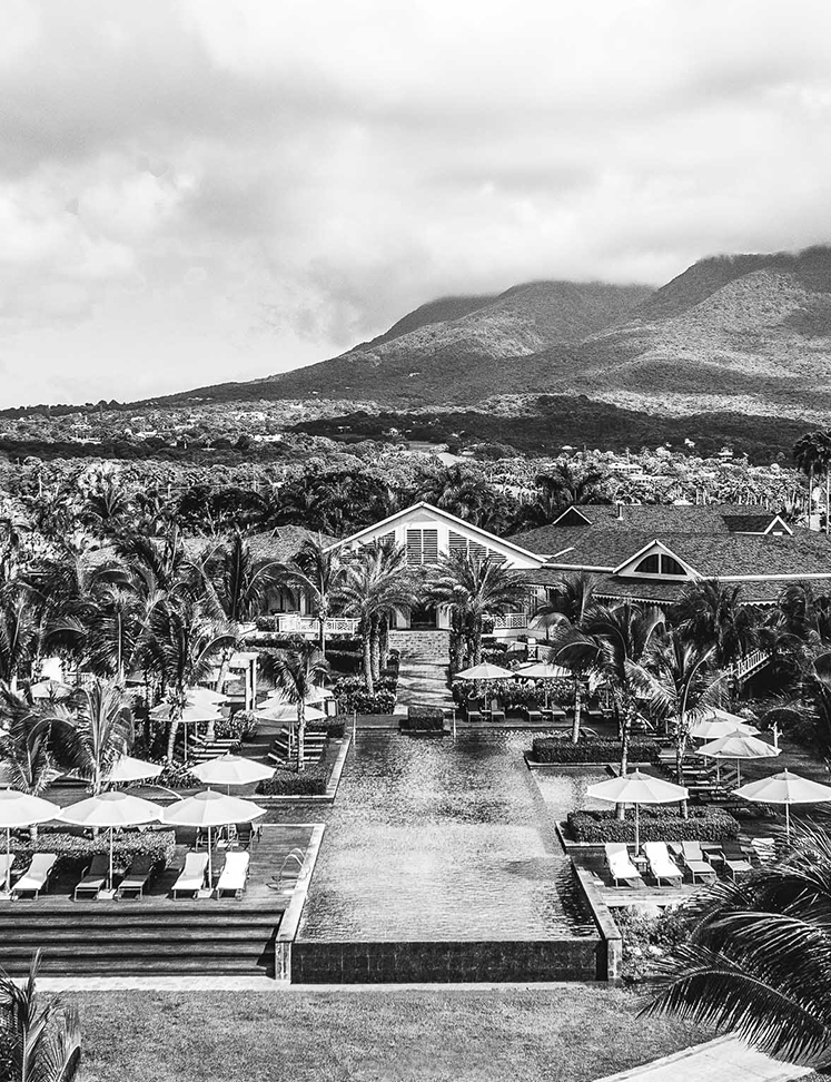 a pool with umbrellas and chairs in front of a building