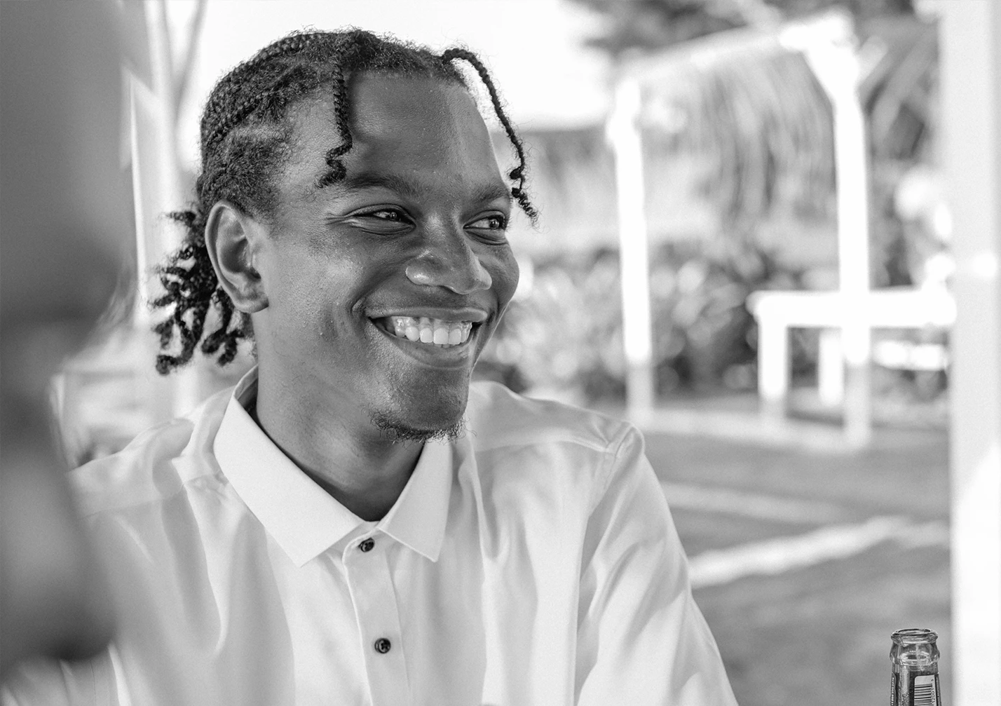 a man smiling in a white shirt