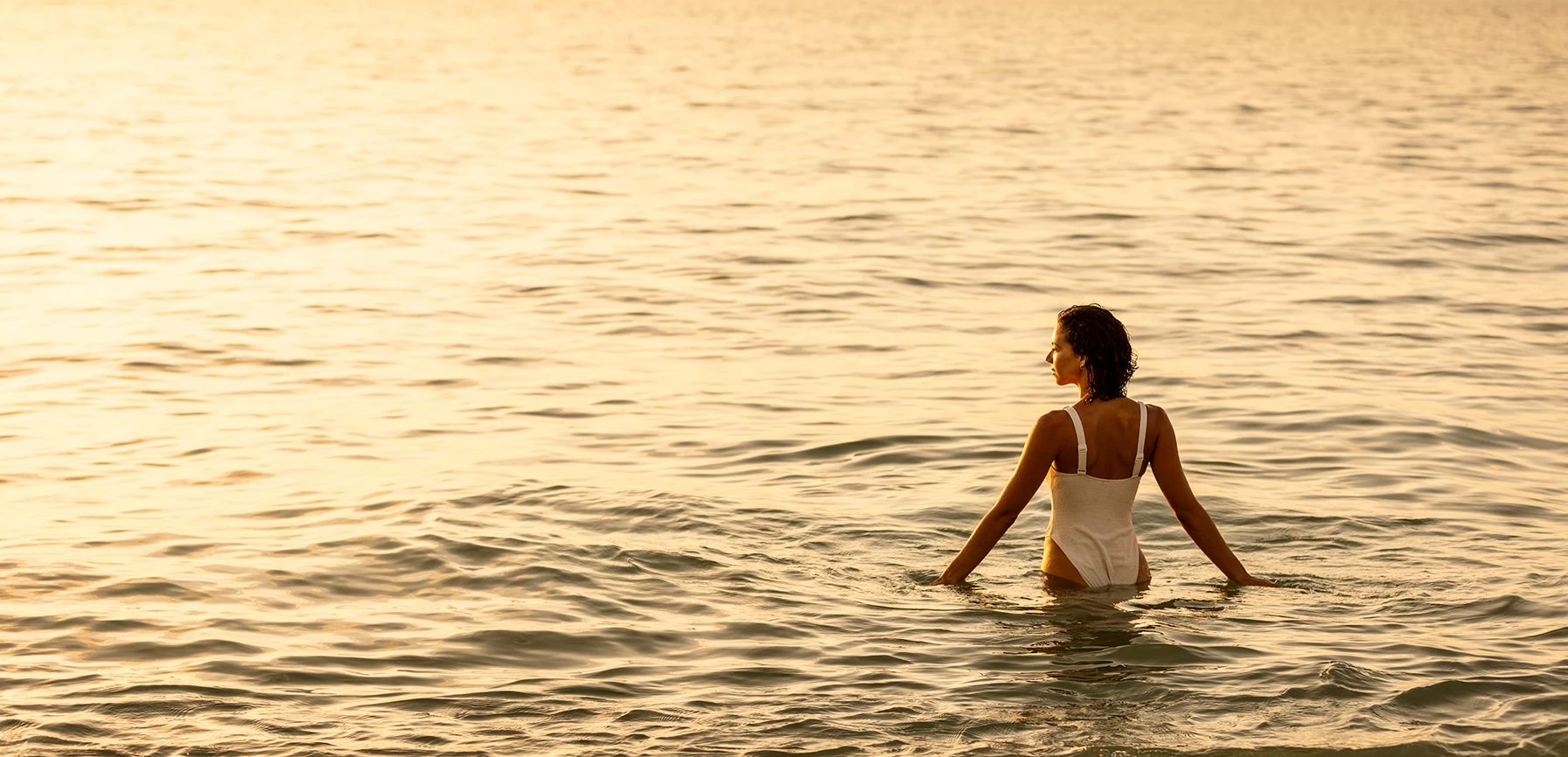 a woman in a white swimsuit standing in water