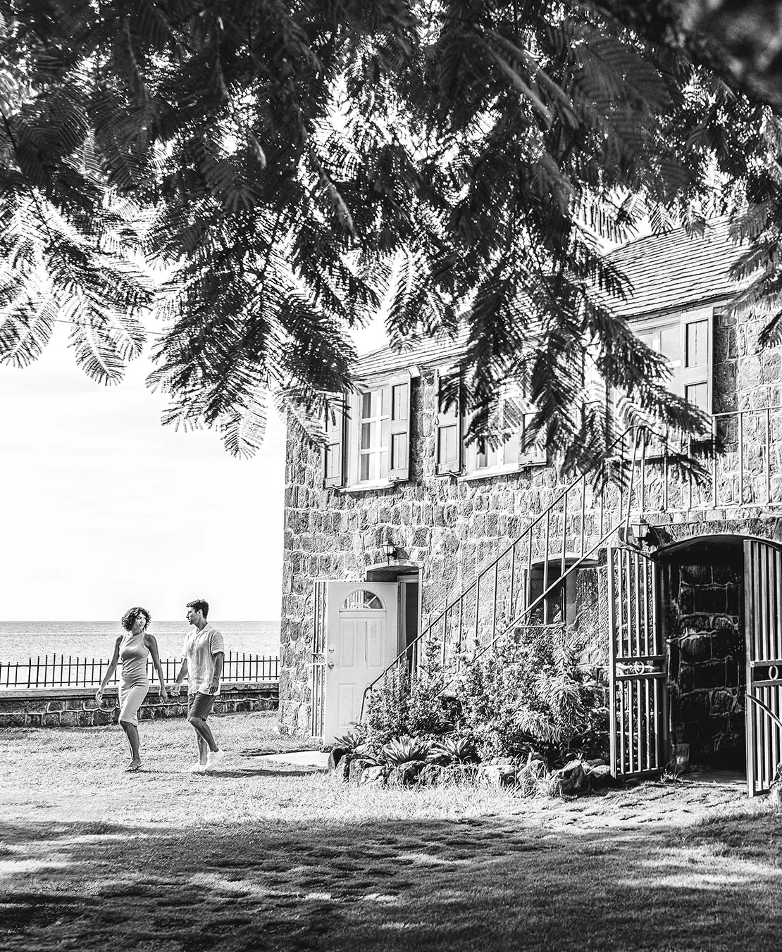 a man and woman walking in front of a stone building