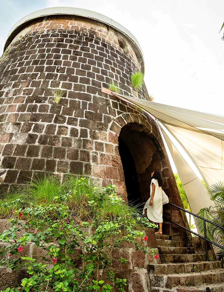 a woman walking up the stairs of a stone tower