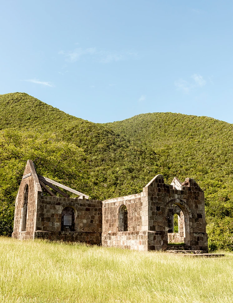 a stone building with a hill in the background