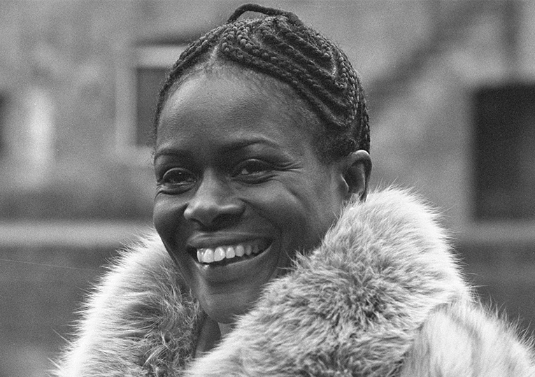 a woman smiling with a fur collar