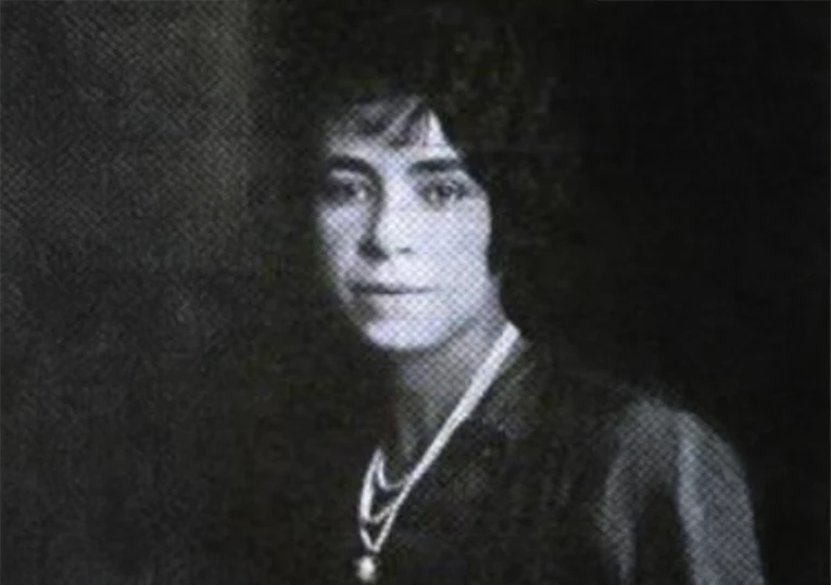 a man with long hair wearing a necklace