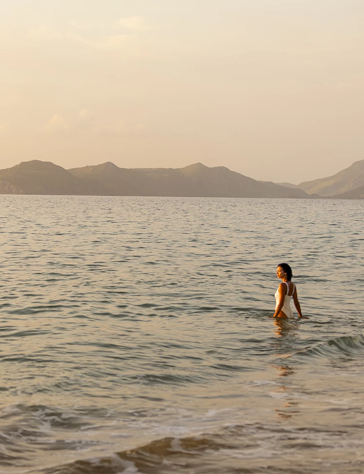 a woman in a white dress standing in the water