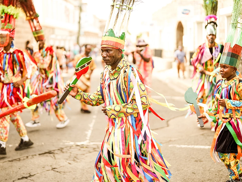 a group of people in colorful clothing walking down a street
