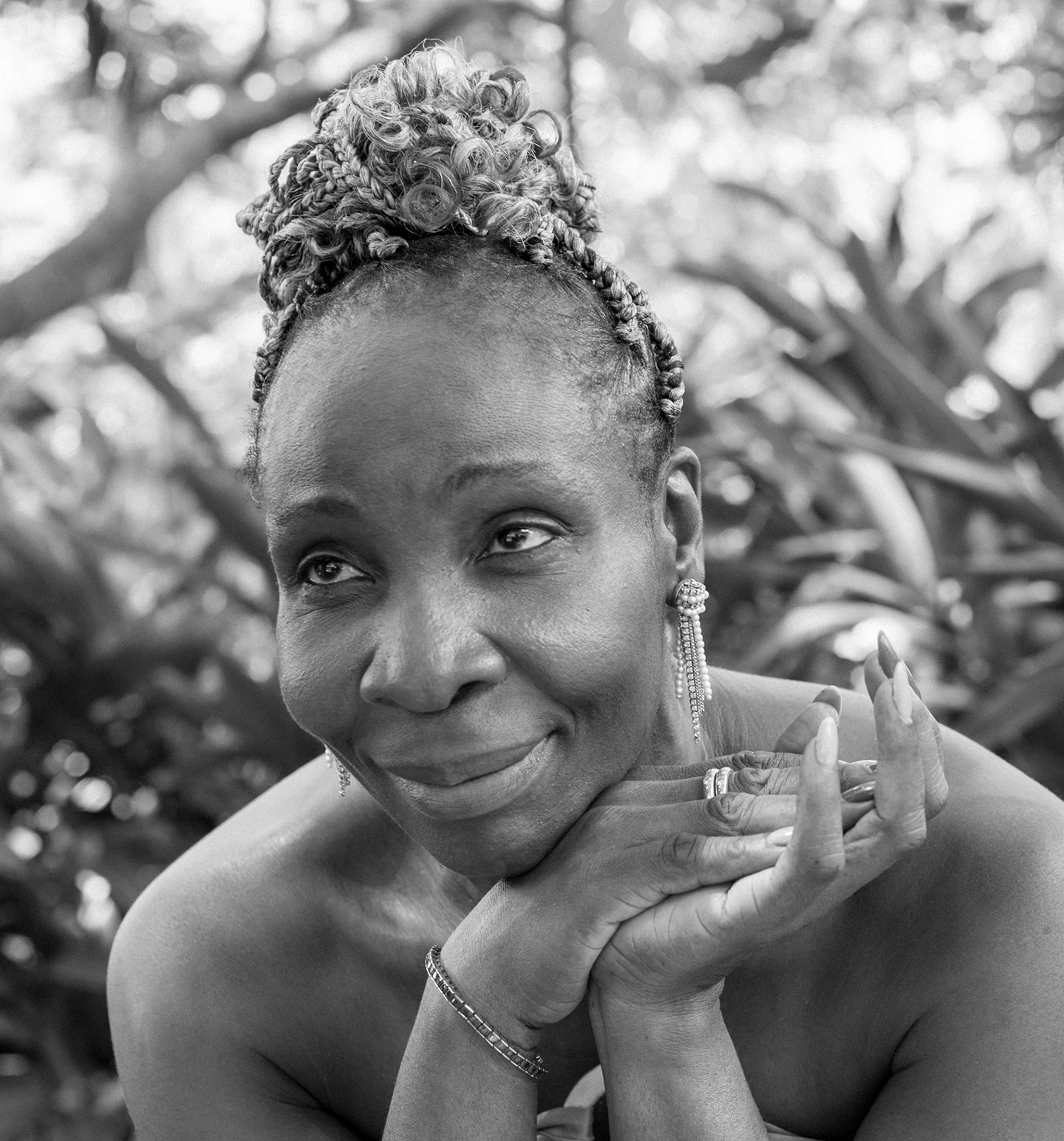 a woman smiling with her hands on her chin