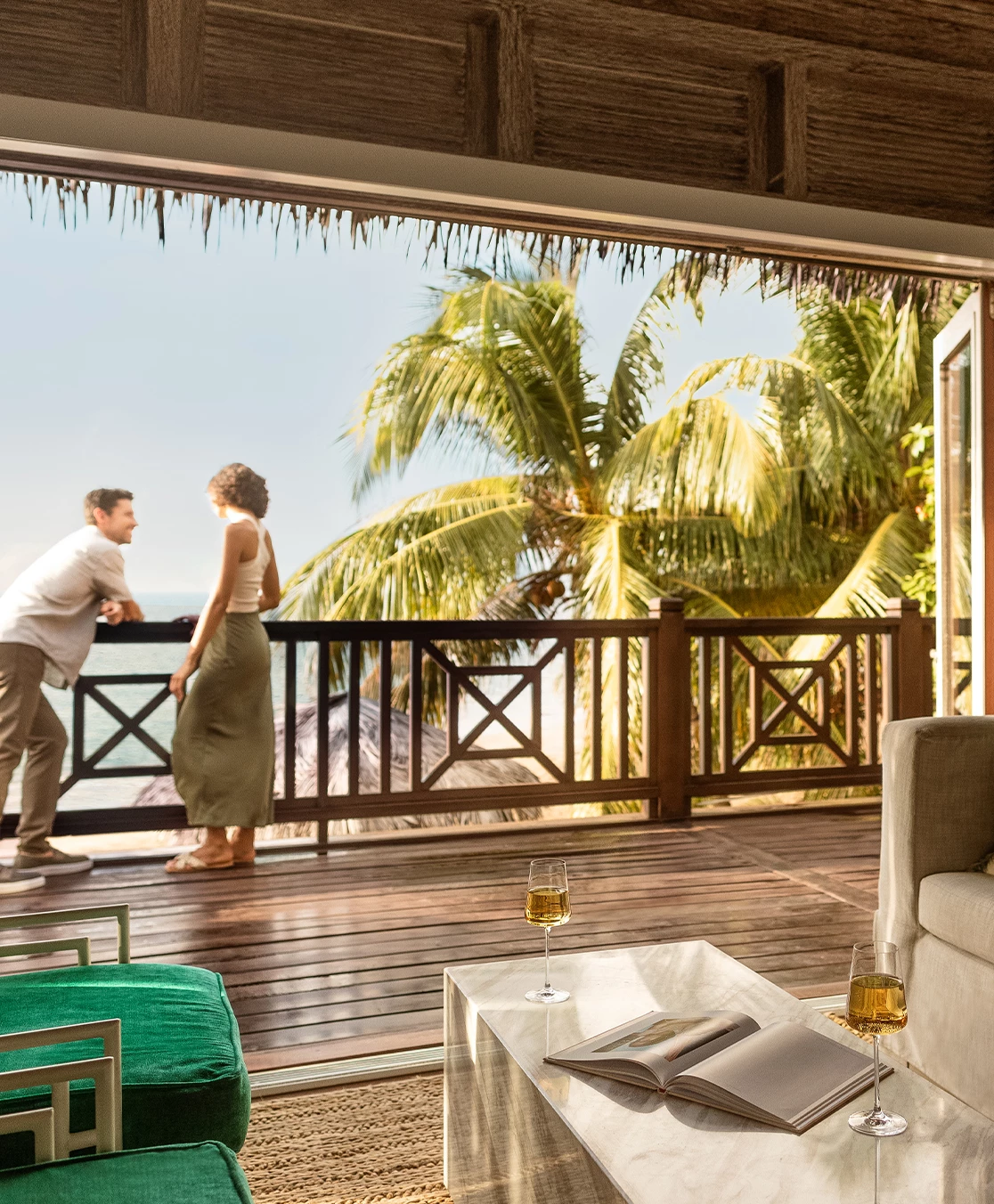 a man and woman standing on a deck looking out to the ocean