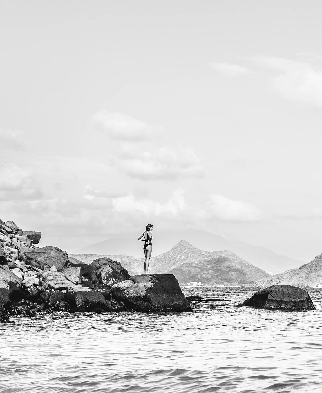 a woman standing on rocks in water