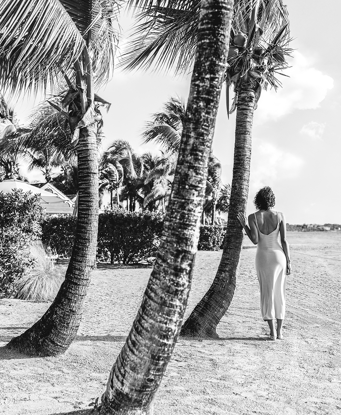 a woman standing on a beach with palm trees