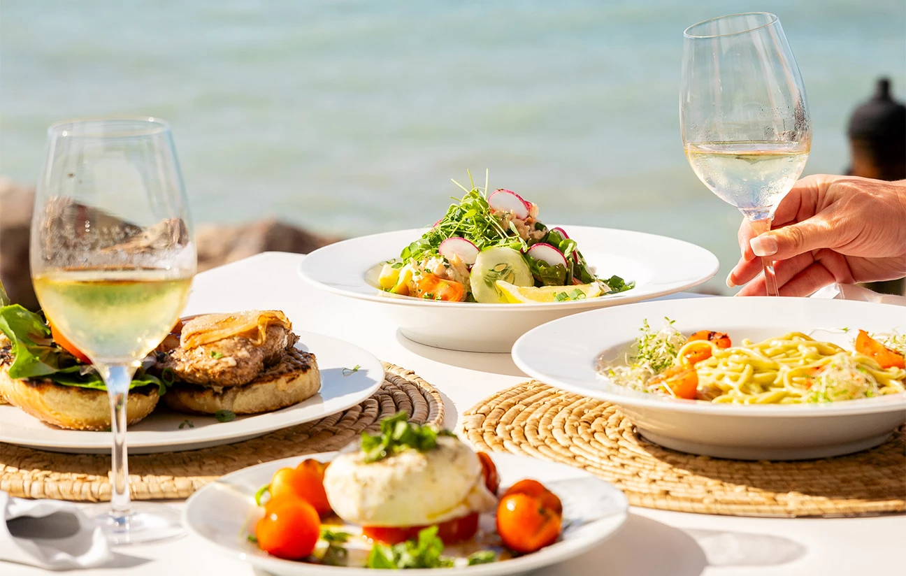 a table with plates of food and wine glasses