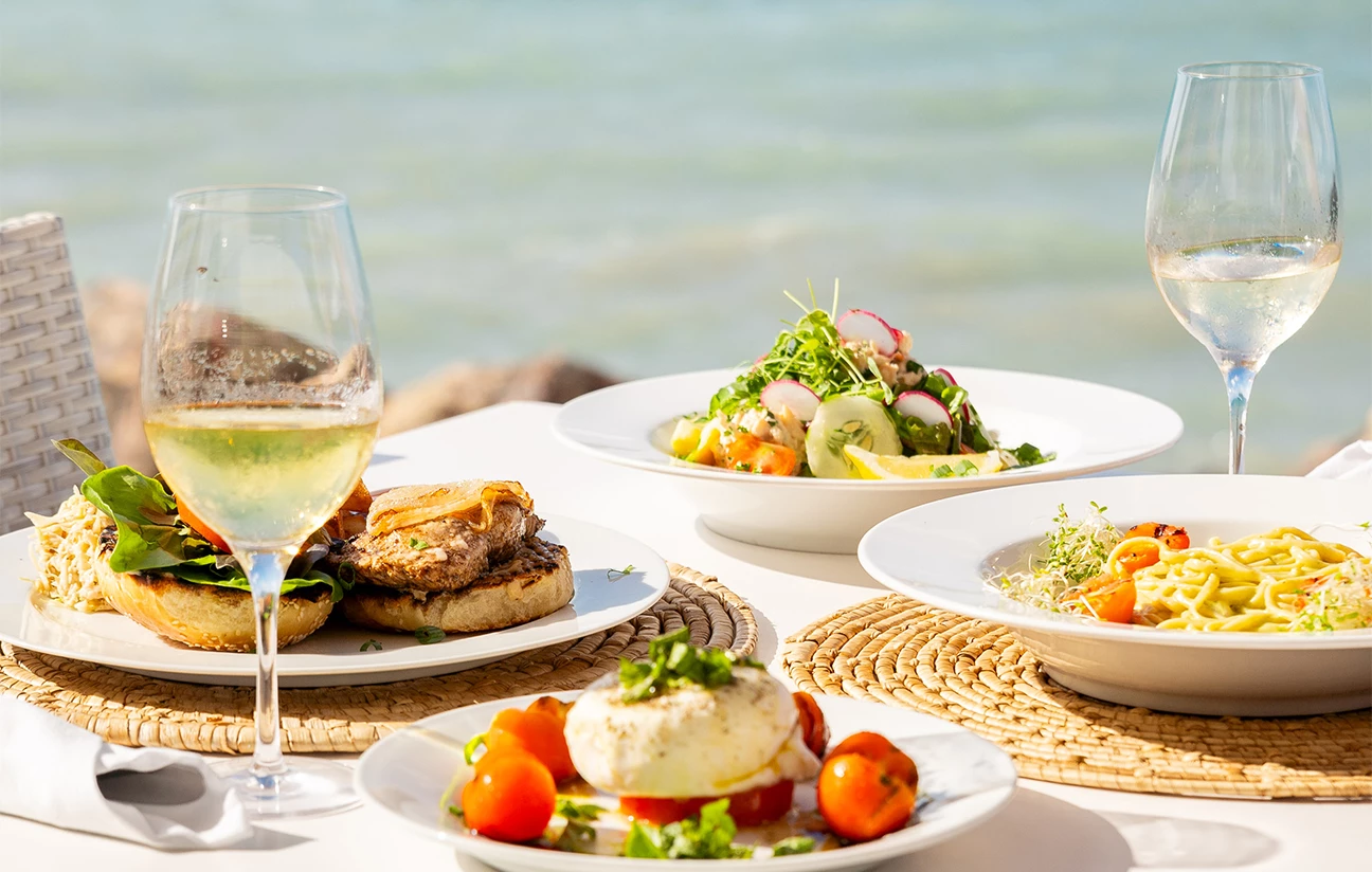 a table with plates of food and a glass of wine
