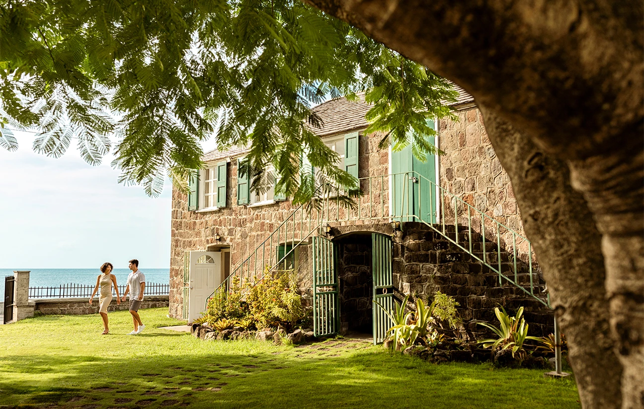 a man walking in front of a stone building