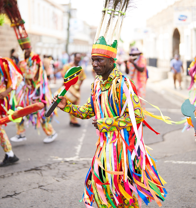 a group of people in colorful clothing walking down a street