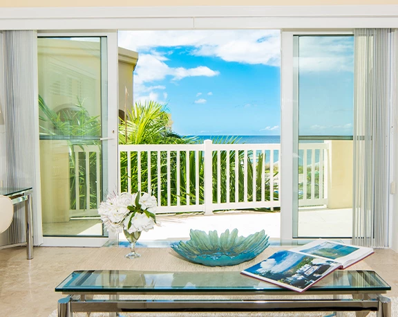 a beach with buildings and trees and a mountain in the background