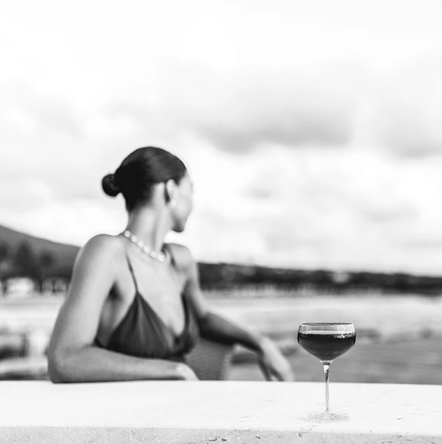 a woman sitting at a table with a glass of wine