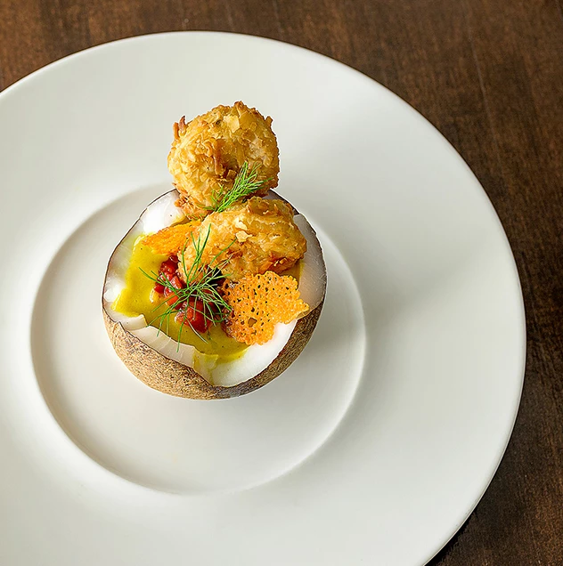 a half of an egg with sauce on a white plate