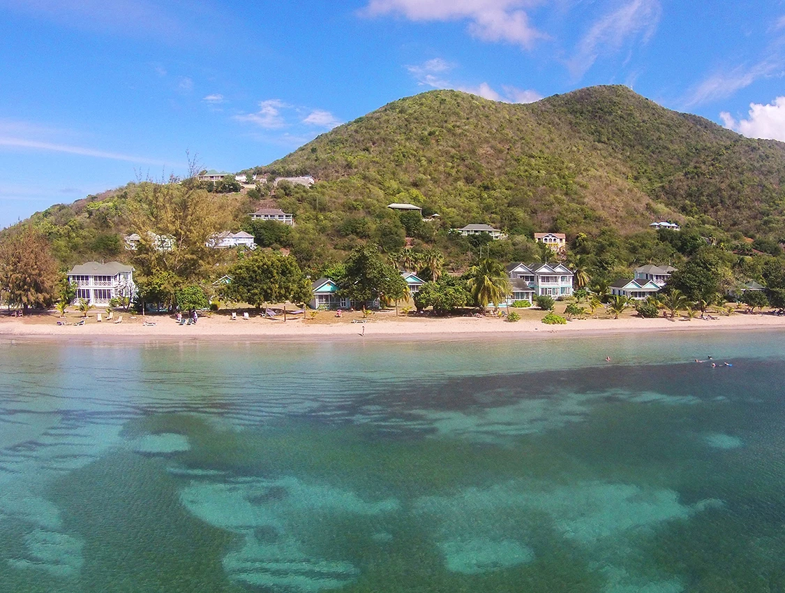 a beach with houses and a hill