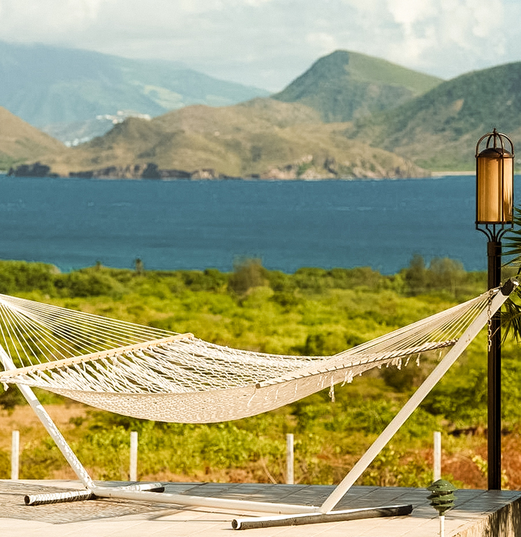 a hammock on a deck overlooking a body of water