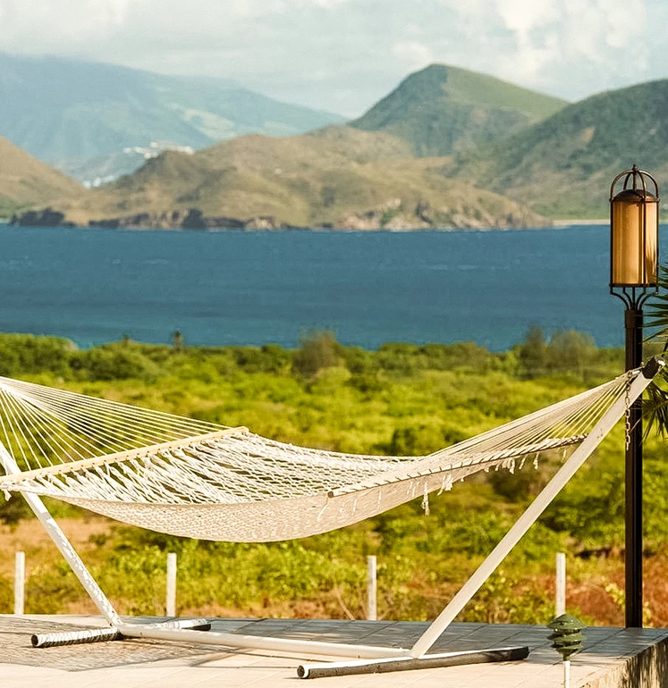 a hammock on a deck overlooking a body of water