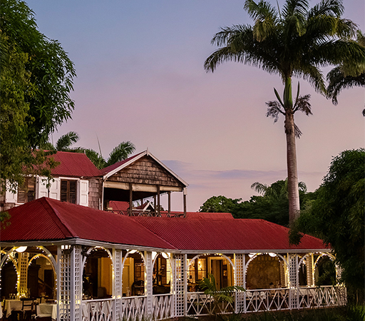a building with a red roof and palm trees