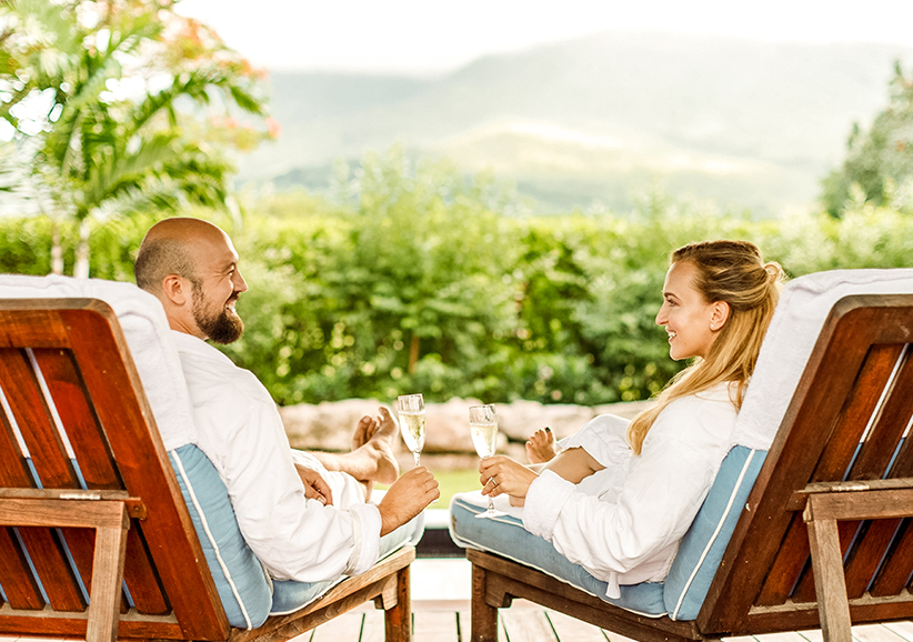 a man and woman sitting in chairs with drinks