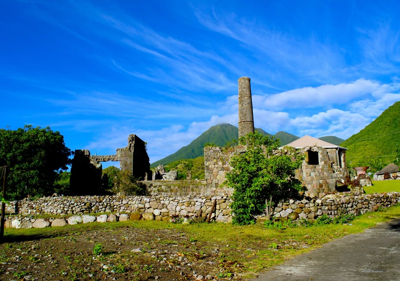 a stone building with a chimney and a stone wall
