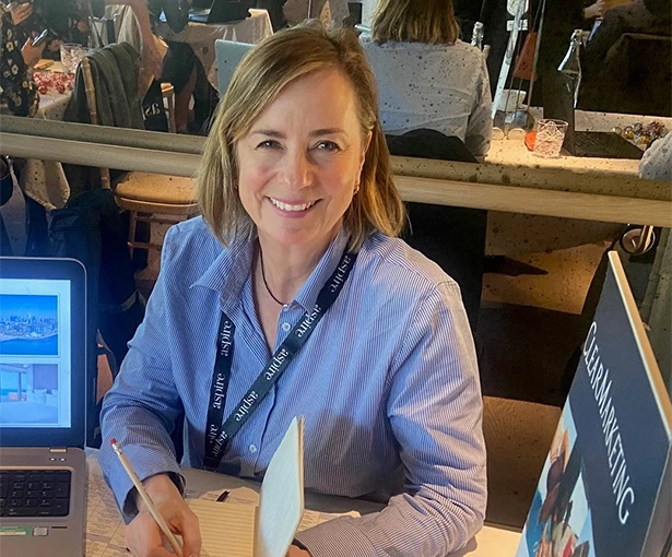 a woman sitting at a table with a laptop and a notebook