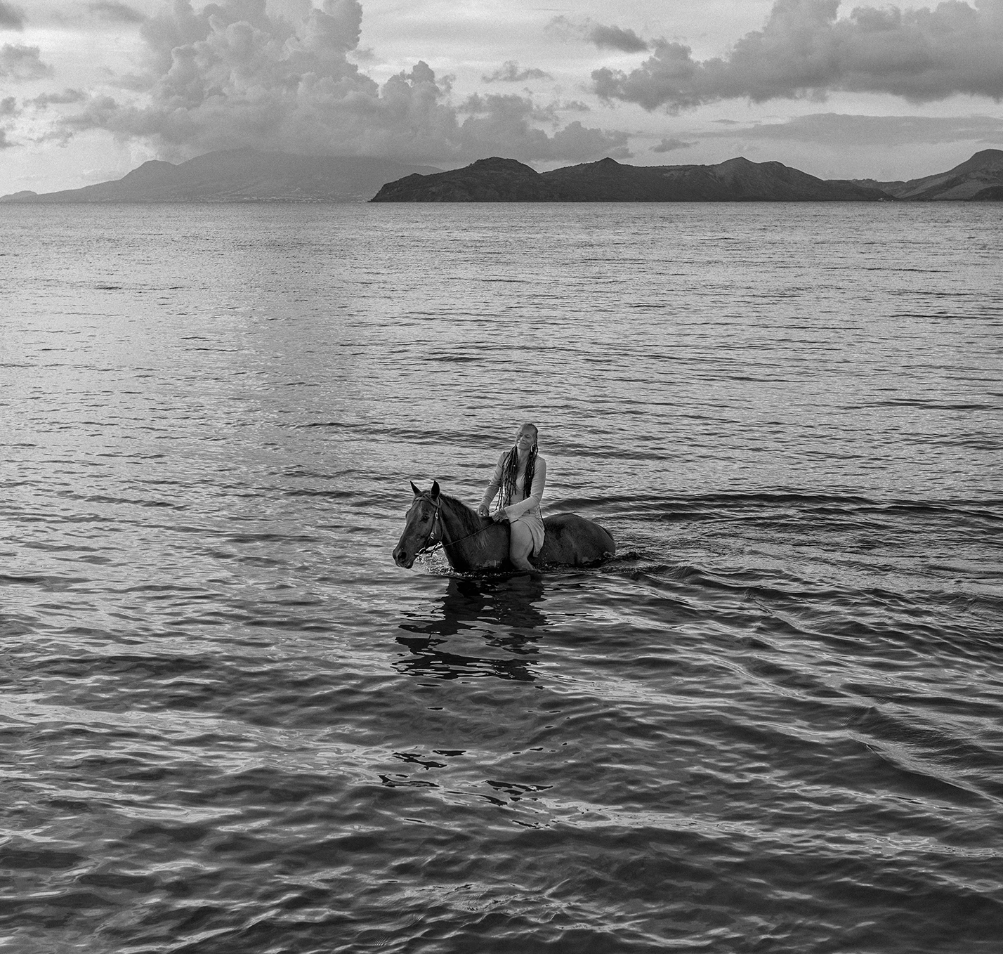 a woman riding a horse in the water