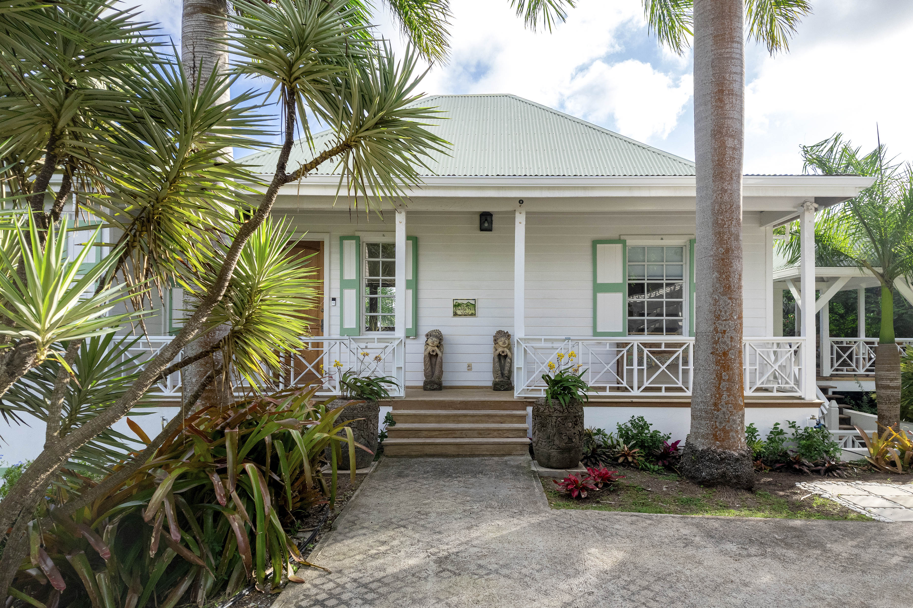 a house with palm trees and a stone walkway