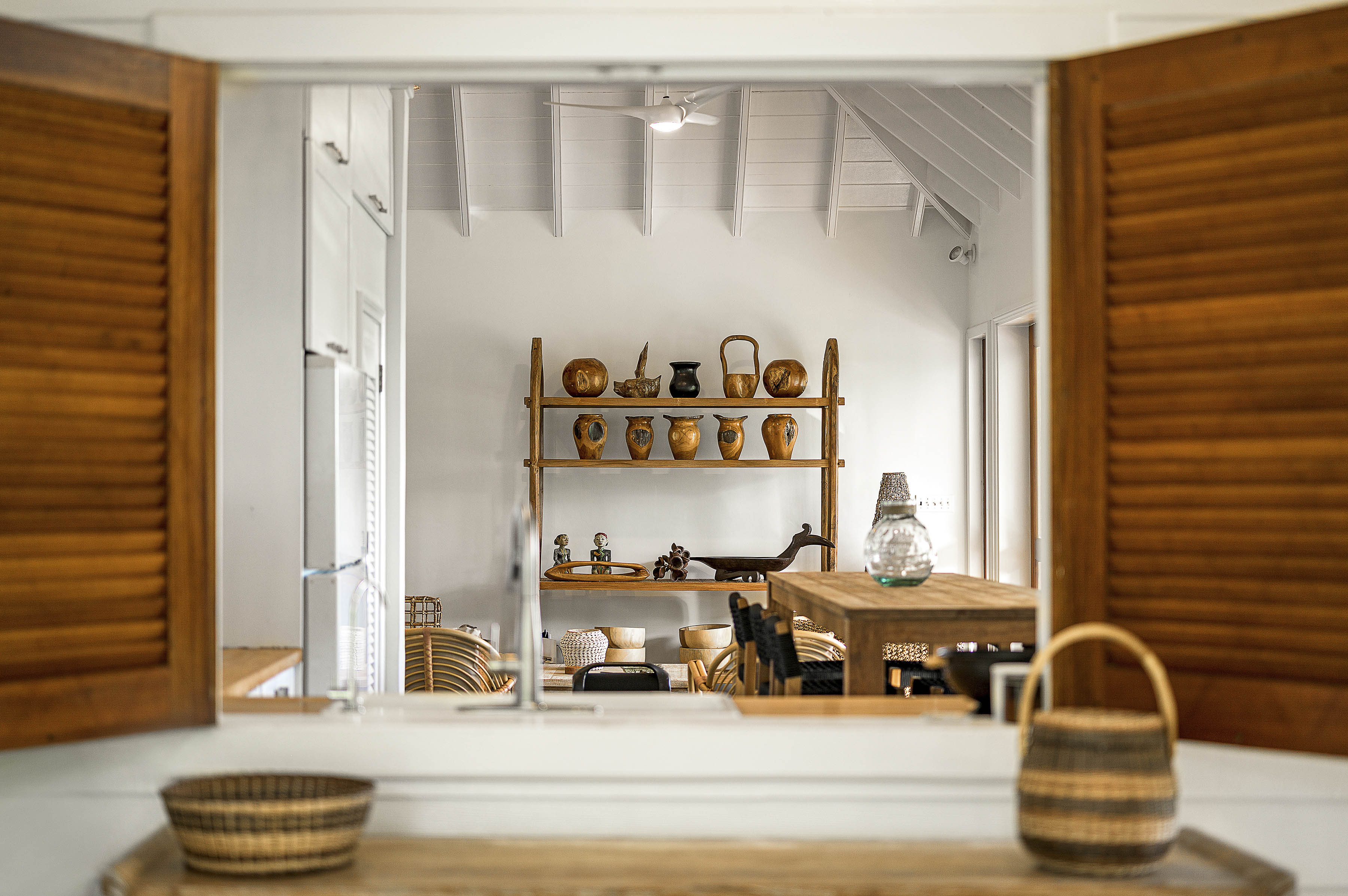 a room with a table and chairs and a shelf with objects on it