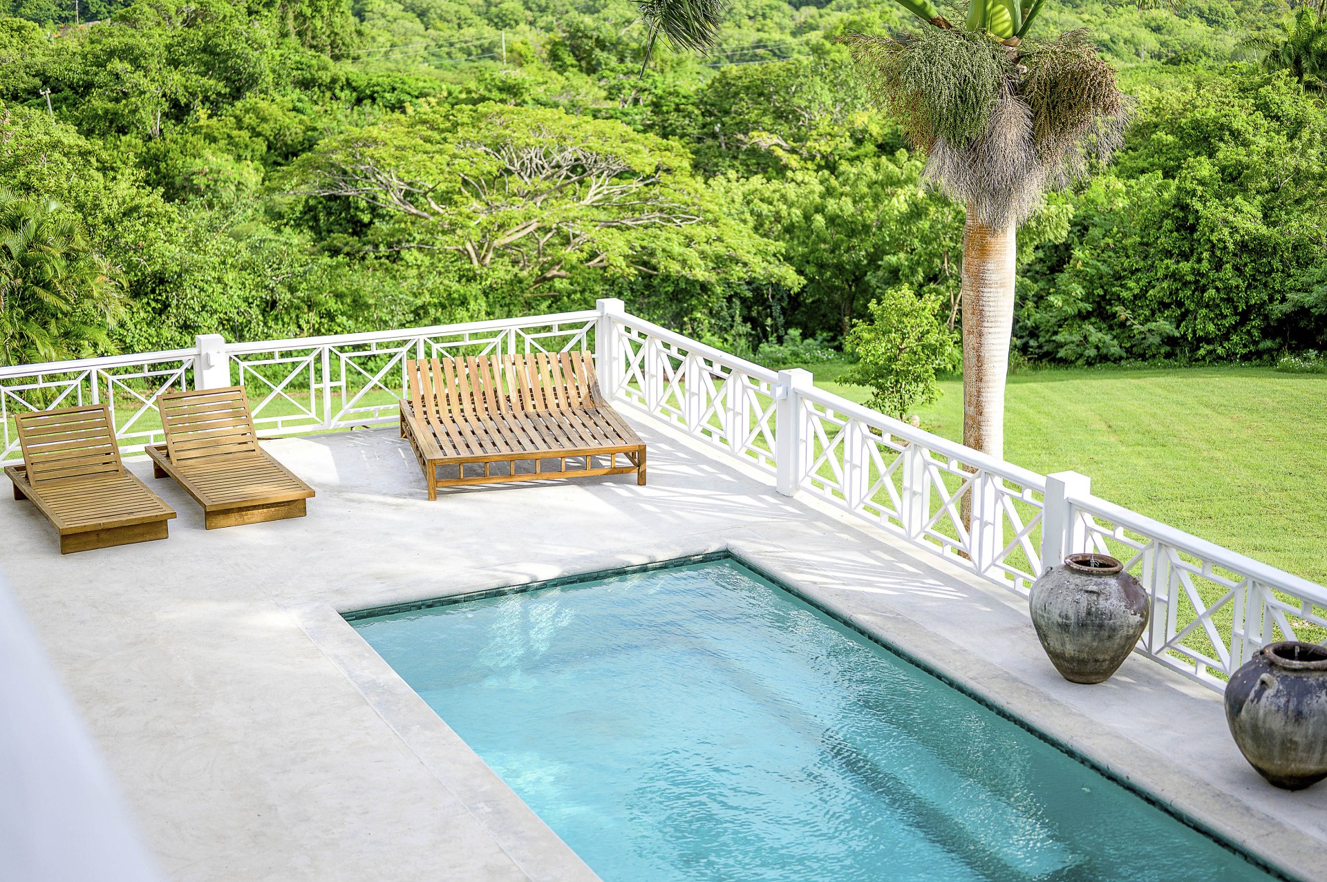 a pool and lounge chairs on a deck