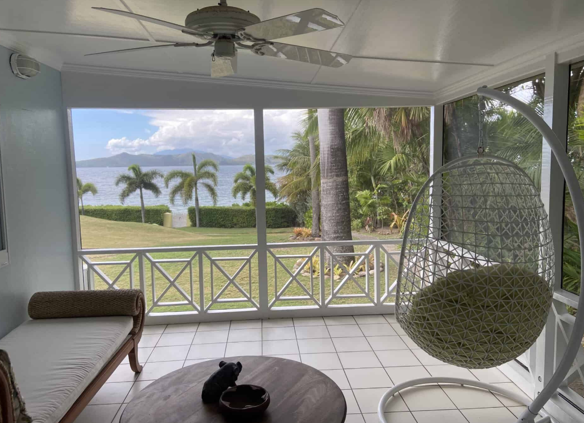 a room with a chair and a view of the ocean