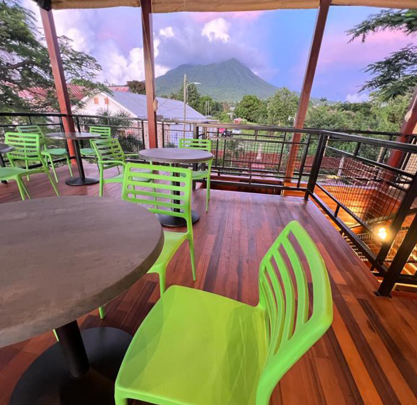 a green chairs and tables on a deck