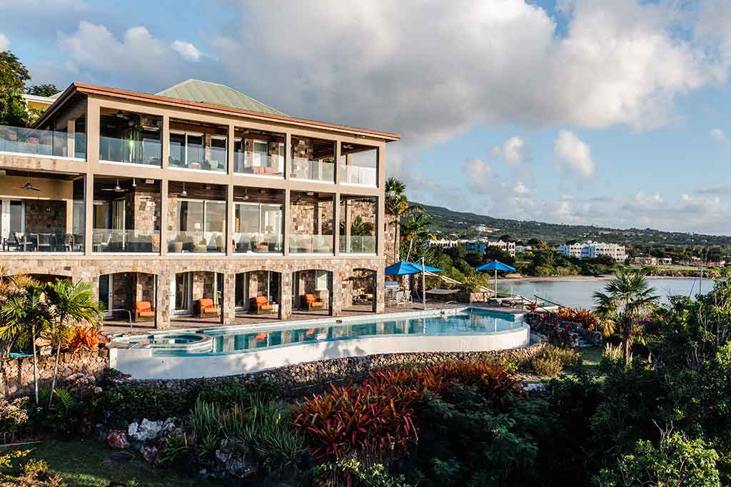 a building with a pool and a body of water