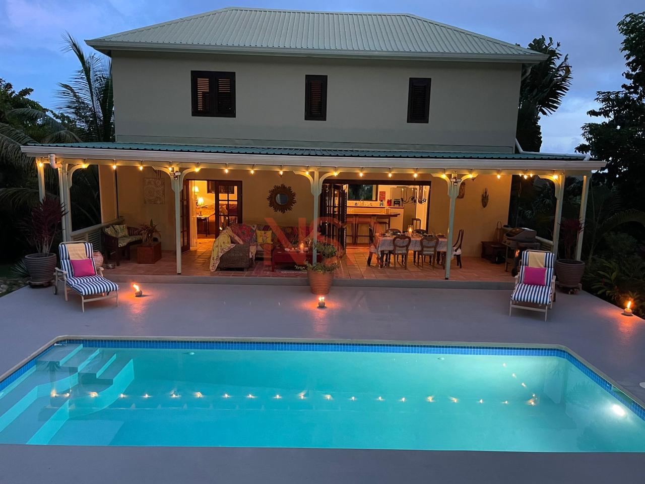 a pool with lights on the side of a house