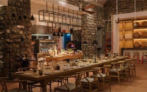 a large dining room with a stone wall and stone walls