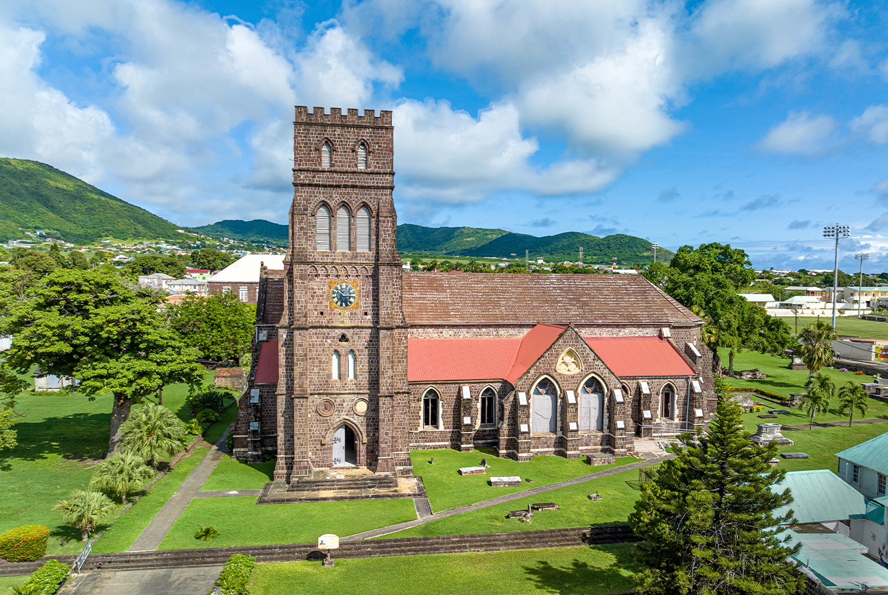 St. George's Anglican Church with a clock tower and grass