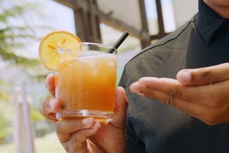 a person holding a glass of orange juice