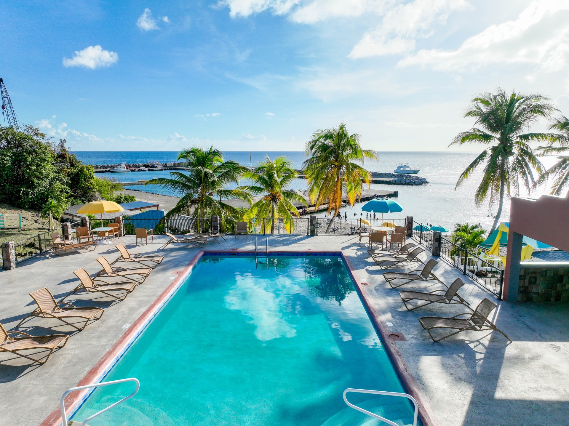 a pool with chairs and umbrellas by the water