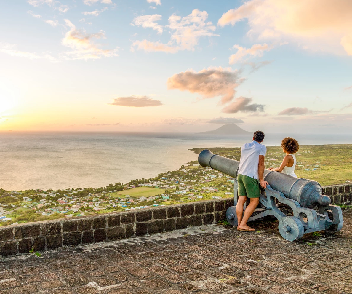 a man and a woman on a cannon overlooking a body of water