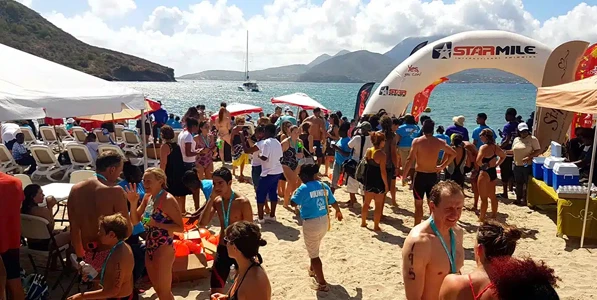 a group of swimming competitors at a beach wearing medals
