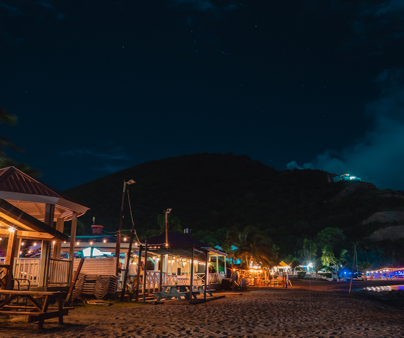 a beach with buildings and lights at night