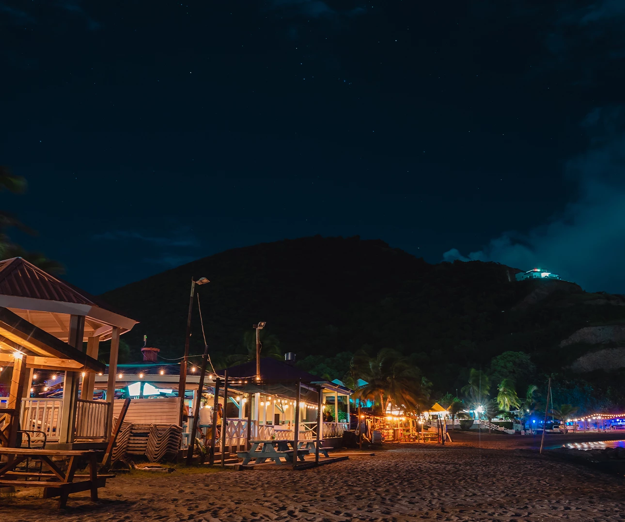 a beach with buildings and lights at night