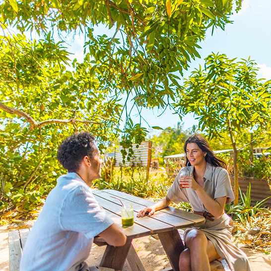a man and woman sitting at a table outside