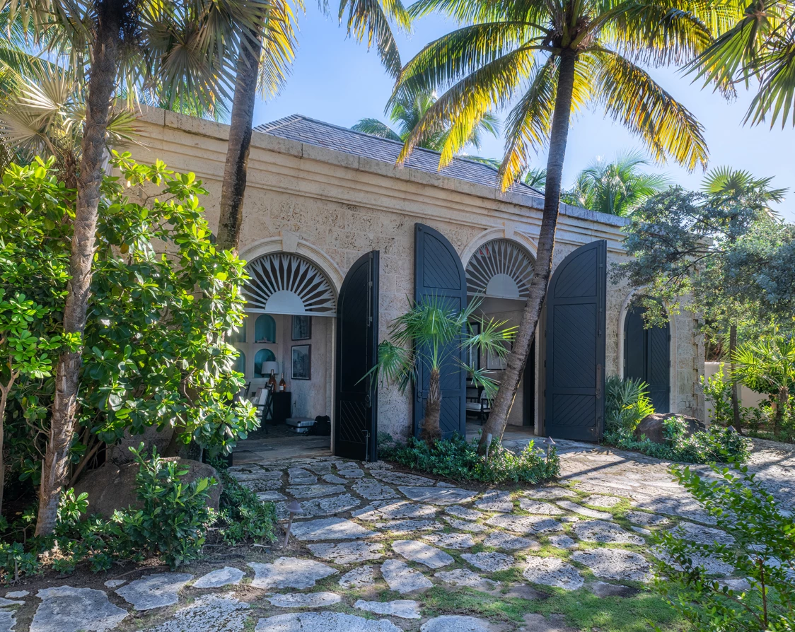 a building with palm trees and a stone walkway