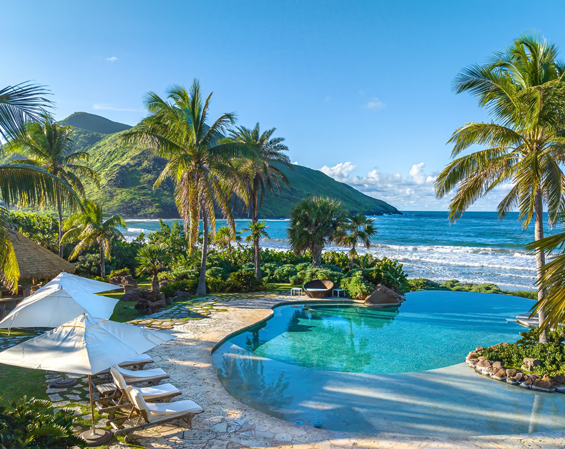 a pool with chairs and umbrellas next to a beach